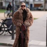 Leonie Hanne is seen wearing burgundy oversized shield frame sunglasses with wide temples from Stella McCartney, silver drop-shaped earrings from...