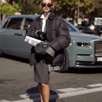 Leonie Hanne wears dark geri skirt, white shirt oversized jacket and black bag outside the Miu Miu show during Womenswear Spring/Summer 2025 as part...