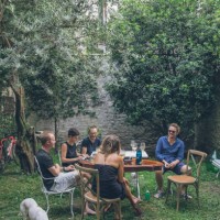 les amis déjeunent dans une cour luxuriante, en été - garden decoration photos et images de collection