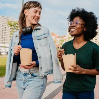 lesbian couple eating lunch outside - junk food stock pictures, royalty-free photos & images