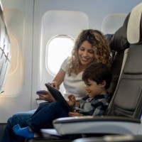 liebende mutter und sohn spielen mit tablet während eines fluges sieht sehr glücklich - travel stock-fotos und bilder