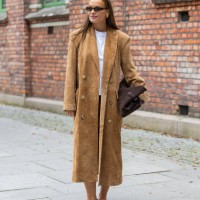 Lisa Alexandra wears brown wild leather coat, bag, skirt, white tshirt at Oslo Fashion Week 2024 on August 27, 2024 in Oslo, Norway.