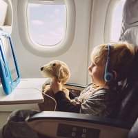 little boy sitting on an airplane watching something on digital tablet - travel stock pictures, royalty-free photos & images