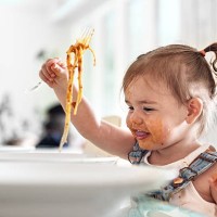 little girl 2 years old girl eating noodles - food stockfoto's en -beelden