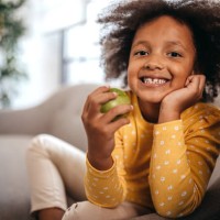 little girl eating apple at home - food stock pictures, royalty-free photos & images
