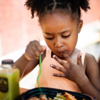 little girl eating take out food outdoors. - junk food stock pictures, royalty-free photos & images