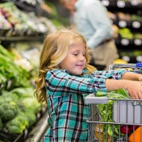little girl helping mother shop for produce in grocery store - food stock pictures, royalty-free photos & images