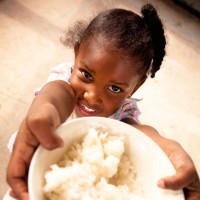 little girl holds bowl of rice - food stock pictures, royalty-free photos & images