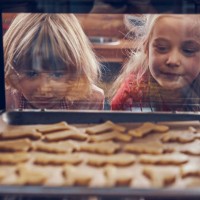 little girls waiting for christmas cookies to bake in the oven - food stock pictures, royalty-free photos & images