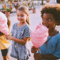 little multi-ethnic children eating cotton candy at amusement park - food stock pictures, royalty-free photos & images