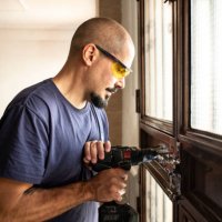 locksmith changes a lock at home with a battery drill - home decoration stock pictures, royalty-free photos & images
