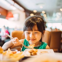 lovely little girl having meals joyfully - junk food stock pictures, royalty-free photos & images