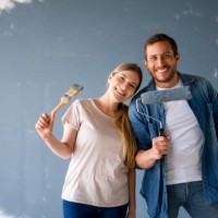 loving couple looking very happy renovating their house and painting the walls - home decoration stock pictures, royalty-free photos & images
