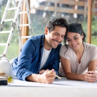 loving couple remodeling their house and looking at a blueprint - home decoration stock pictures, royalty-free photos & images