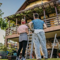 low angle adult couple checking their balcony fence after hard painting work - home decoration stock pictures, royalty-free photos & images