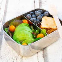 lunchbox with salad, avocado and yellow tomatoes, crackers and blueberries - junk food stock pictures, royalty-free photos & images