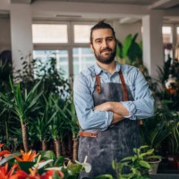 männlicher florist im blumenladen - garden decoration stock-fotos und bilder