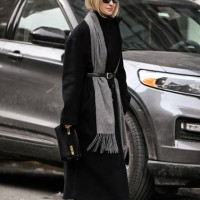 Madeline Harper Fass is seen wearing a black coat, black belt, gray scarf and black sunglasses outside the Kallmeyer show during NYFW F/W 2025 on...