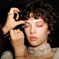Makeup artist applies makeup to a model backstage at the Ermanno Scervino fashion show during the Milan Fashion Week - Womenswear Fall/Winter...