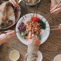 malaysian chinese family chinese new year reunion dinner having traditional dishes raw fish lau sang yee sang - food stock pictures, royalty-free photos & images