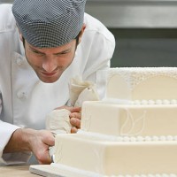 male chef icing wedding cake in kitchen - garden decoration stock pictures, royalty-free photos & images