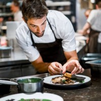 male cook preparing food in commercial kitchen - food stock pictures, royalty-free photos & images