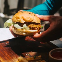 male hands holding vegan burger with bean patty - junk food stock pictures, royalty-free photos & images