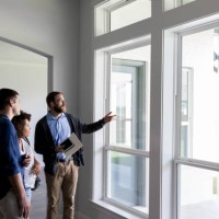 male real estate agent shows a couple a beautiful home - home decoration stock pictures, royalty-free photos & images