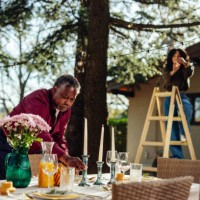 man and woman decorating table and yard for outdoors party - garden decoration stock pictures, royalty-free photos & images