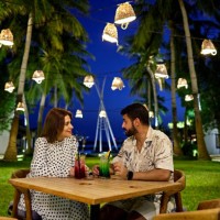 man and woman enjoying drinks sitting in resort garden - garden decoration stock pictures, royalty-free photos & images