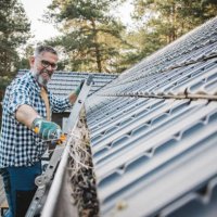 man cleaning leaves from guttering of house - home decoration stock pictures, royalty-free photos & images
