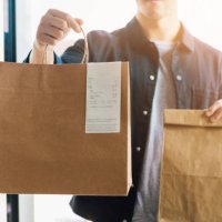man delivering takeaway food at the front door - junk food stock pictures, royalty-free photos & images