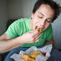man devouring waffle fries - junk food stock pictures, royalty-free photos & images