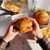 man eating a cheeseburger with french fries, personal perspective view - junk food stock pictures, royalty-free photos & images