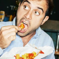 man eating bag of chips - food stock pictures, royalty-free photos & images