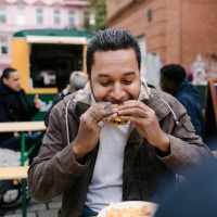 man eating burger from food truck - food stockfoto's en -beelden