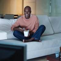 man eating chinese food watching television - junk food stock pictures, royalty-free photos & images