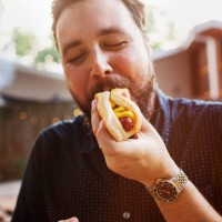 man eating hot dog at yard - junk food stock pictures, royalty-free photos & images