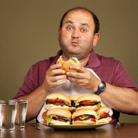 man eating many burgers - food stock pictures, royalty-free photos & images