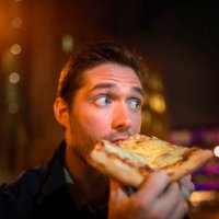 man eating pizza on city street - junk food stock pictures, royalty-free photos & images