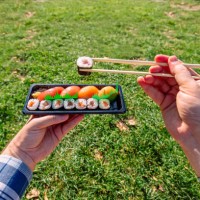 man eating takeaway sushi in the park, personal perspective view - junk food stock pictures, royalty-free photos & images