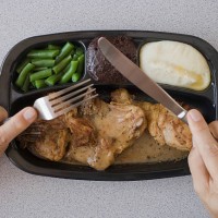 man eating tv dinner - junk food stock pictures, royalty-free photos & images