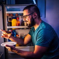 man eats sweets at night - food stock pictures, royalty-free photos & images
