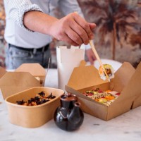 man eats takeaway sushi at home - junk food stock pictures, royalty-free photos & images