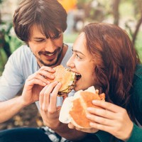 man feeding his girlfriend - junk food stock pictures, royalty-free photos & images