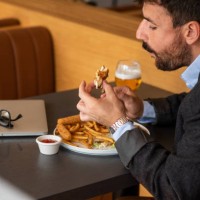 man finishing his burger - junk food stock pictures, royalty-free photos & images
