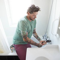 man fixing valve of bathtub at home - home decoration stock pictures, royalty-free photos & images