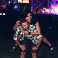 man giving piggy back to his friend in front of the stage - concert stock pictures, royalty-free photos & images