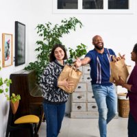 man handing takeaway paper bags to female friends - junk food stock pictures, royalty-free photos & images