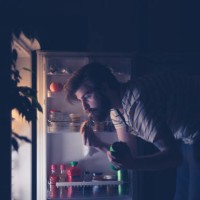 man having snack and drinking beer late night in front of the refrigerator - junk food stock pictures, royalty-free photos & images